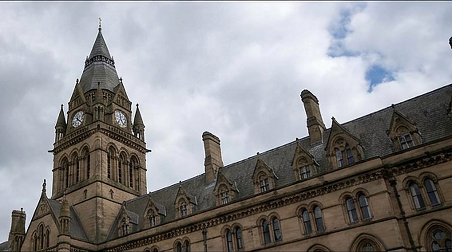 Manchester Town Hall clock tower under a cloudy sky